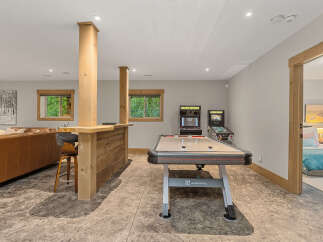 This finished basement offers the ultimate entertainment space, featuring a full-size air hockey table and classic arcade games.