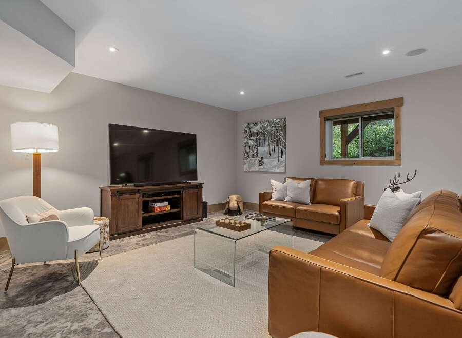Experience ultimate comfort in this inviting living room, featuring plush leather sofas and a cozy armchair perfect for relaxation.