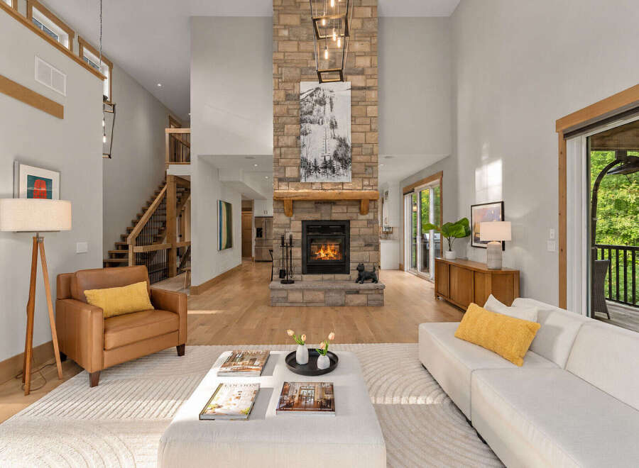 Experience modern living in this stunning great room, featuring a soaring stone fireplace and abundant natural light.