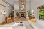 Experience modern living in this stunning great room, featuring a soaring stone fireplace and abundant natural light.
