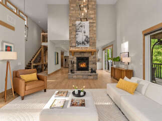 Experience modern living in this stunning great room, featuring a soaring stone fireplace and abundant natural light.