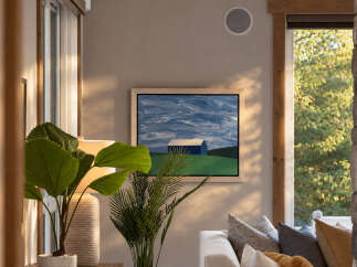 This living room features a modern aesthetic with a large abstract painting of a blue barn and sky above a white sofa.