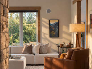 Experience rustic charm and modern comfort in this inviting living space, featuring a natural stone accent wall and a large window framing lush greenery.