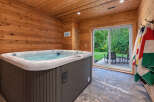 Indulge in relaxation in this luxurious indoor hot tub room, featuring warm wood paneling and a spacious jacuzzi.