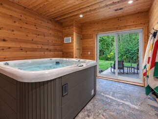 Indulge in relaxation in this luxurious indoor hot tub room, featuring warm wood paneling and a spacious jacuzzi.