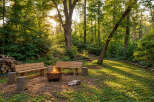 Experience the perfect outdoor retreat with this inviting fire pit area, nestled within a serene wooded landscape.