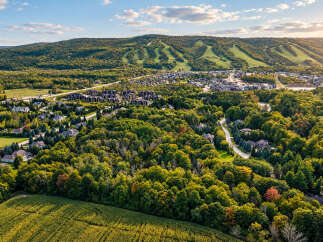 Experience the beauty of autumn in this stunning aerial view of a residential area nestled amongst vibrant fall foliage.
