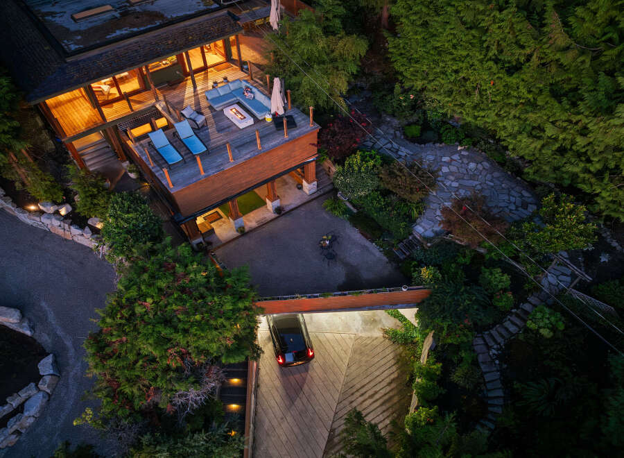 Experience luxury living in this stunning multi-level home, featuring a spacious deck with a modern fire pit and comfortable seating, perfect for entertaining.