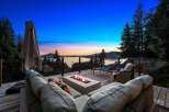 Experience breathtaking sunset views from this stunning deck, complete with a modern fire pit and comfortable seating.