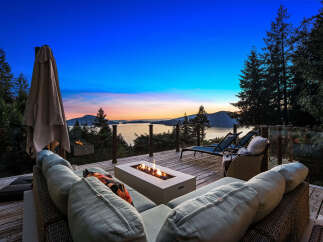 Experience breathtaking sunset views from this stunning deck, complete with a modern fire pit and comfortable seating.