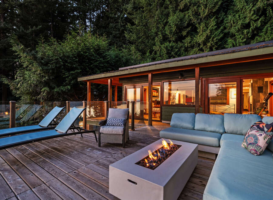 Experience ultimate relaxation on this stunning deck, featuring a modern fire pit and comfortable lounge seating perfect for evening gatherings.