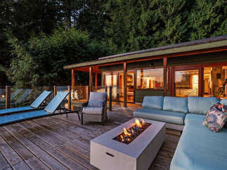 Experience ultimate relaxation on this stunning deck, featuring a modern fire pit and comfortable lounge seating perfect for evening gatherings.