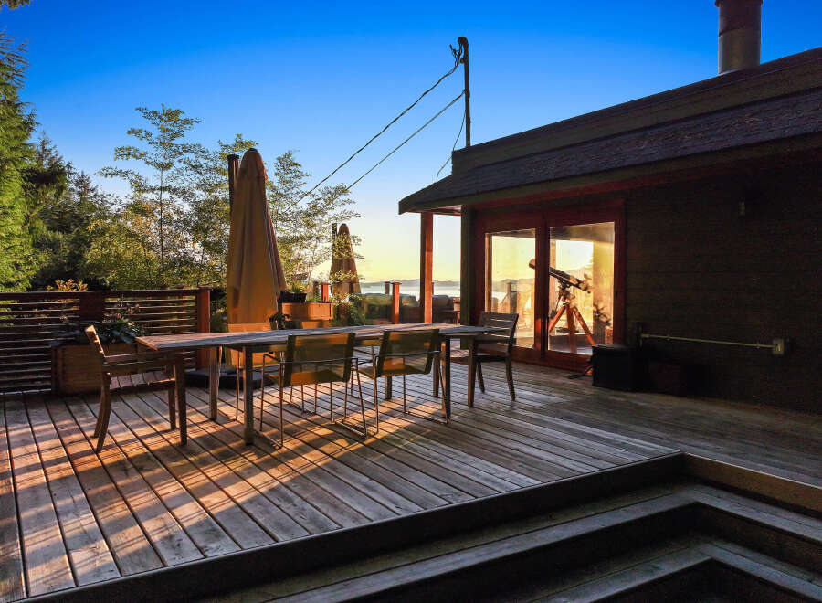 Enjoy breathtaking sunset views from this expansive wooden deck, perfect for outdoor dining and entertaining.