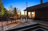 Enjoy breathtaking sunset views from this expansive wooden deck, perfect for outdoor dining and entertaining.