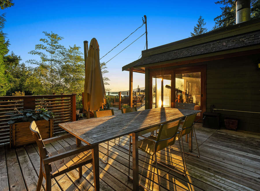 Enjoy breathtaking sunset views from this expansive wooden deck, perfect for outdoor dining and entertaining.