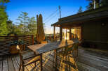 Enjoy breathtaking sunset views from this expansive wooden deck, perfect for outdoor dining and entertaining.