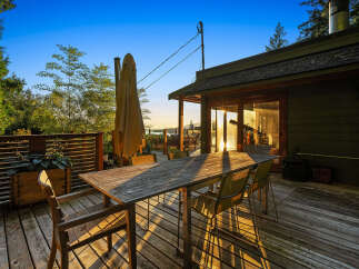 Enjoy breathtaking sunset views from this expansive wooden deck, perfect for outdoor dining and entertaining.
