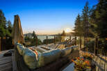 Experience breathtaking sunset views from this stunning deck, complete with a modern fire pit and comfortable seating.