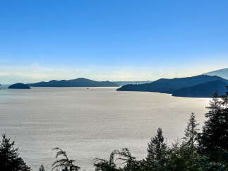 Experience breathtaking panoramic views of the serene ocean and lush, tree-lined islands from this stunning vantage point.