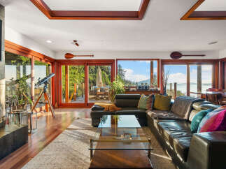 Experience breathtaking ocean views from this stunning living room, featuring a large sectional sofa perfect for relaxing.