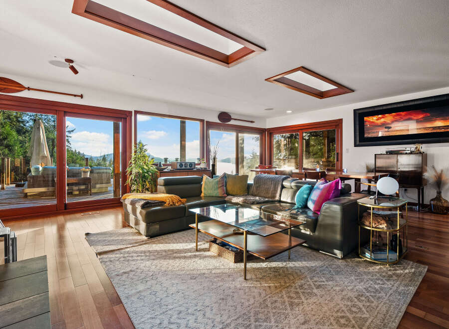 Experience breathtaking views from this stunning living room, featuring expansive windows that flood the space with natural light and showcase the serene natural surroundings.