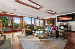 Experience breathtaking views from this stunning living room, featuring expansive windows that flood the space with natural light and showcase the serene natural surroundings.