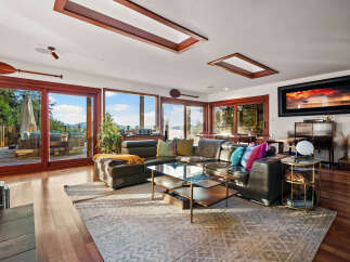 Experience breathtaking views from this stunning living room, featuring expansive windows that flood the space with natural light and showcase the serene natural surroundings.