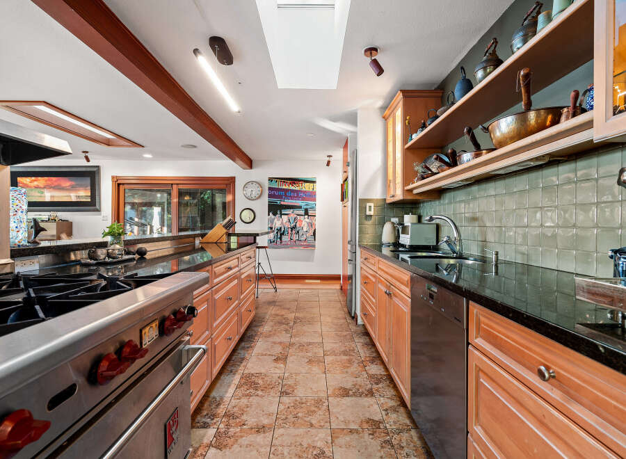 Experience culinary excellence in this spacious kitchen, featuring a professional-grade Wolf range and ample counter space.