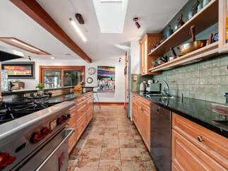 Experience culinary excellence in this spacious kitchen, featuring a professional-grade Wolf range and ample counter space.