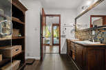 This luxurious bathroom features a rustic wooden vanity with dual vessel sinks and a mosaic tile backsplash.
