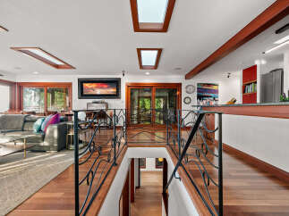 Experience luxurious living in this stunning home featuring a spacious open-concept living area with large windows and skylights that flood the space with natural light.