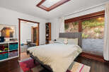 This bedroom offers a comfortable retreat with a plush bed and a cozy reading nook.