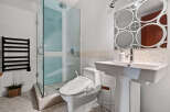 Experience modern luxury in this stunning bathroom, featuring a sleek glass-enclosed shower with soothing blue tiles and a convenient bidet toilet.