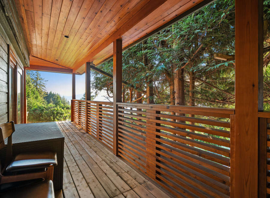 Enjoy breathtaking views from this expansive wooden deck, perfect for outdoor living and entertaining.