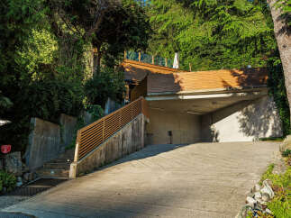 Discover modern living with this stunning property featuring a sleek wooden deck and an integrated garage.