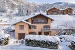 Experience the charm of a winter wonderland with this picturesque property nestled in a snowy mountain landscape.