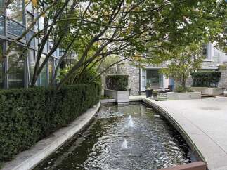 Discover modern living with this stunning property featuring a serene water feature and lush landscaping.