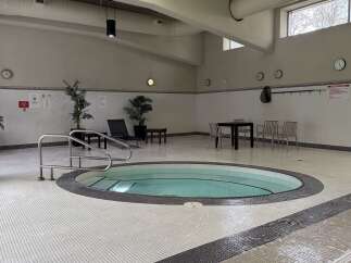 Indulge in relaxation at this indoor jacuzzi, featuring a spacious circular hot tub surrounded by elegant mosaic tiling.