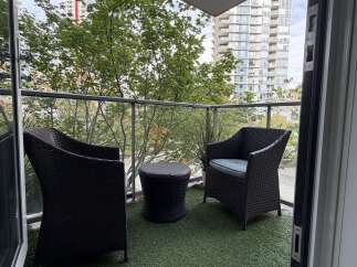 Enjoy your morning coffee or evening relaxation on this charming balcony, complete with two comfortable wicker chairs and a matching side table.