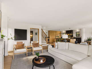 Experience modern living in this open-concept home, featuring a spacious living area with comfortable seating and a sleek black coffee table.