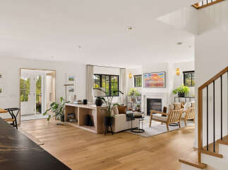 Experience modern living in this bright and airy open-concept space, featuring a stylish living area with a fireplace and comfortable seating.