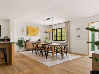 This spacious dining area features a modern wooden dining table with six chairs, perfect for family gatherings.