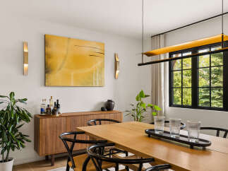 Experience elegant dining in this beautifully appointed space, featuring a warm wooden table and chairs complemented by a stylish sideboard.