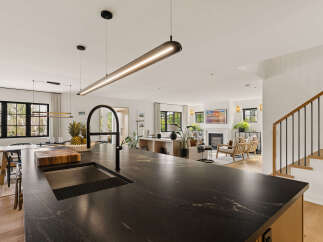 Experience modern living in this open-concept home, featuring a sleek kitchen island with a waterfall countertop and a contemporary faucet.