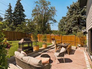 Enjoy outdoor living in this beautifully landscaped backyard featuring a spacious patio with comfortable seating and a dining area.
