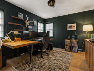 This modern home office features a spacious wooden desk with dual monitors, perfect for productivity.