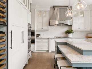 Experience luxury in this stunning white kitchen, featuring a built-in wine fridge and sleek double ovens.