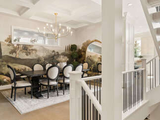 This elegant dining room features a stunning landscape mural that creates a dramatic backdrop for the dark wood dining table and upholstered chairs.