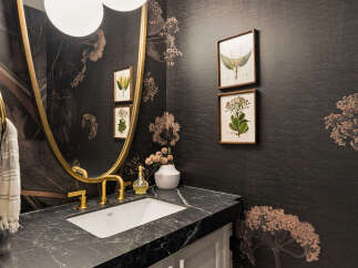 This powder room features a striking dark floral wallpaper that adds a dramatic flair to the space.