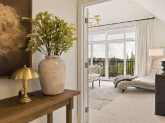 Step into a beautifully appointed living space featuring a plush chaise lounge and elegant seating, perfect for relaxation.